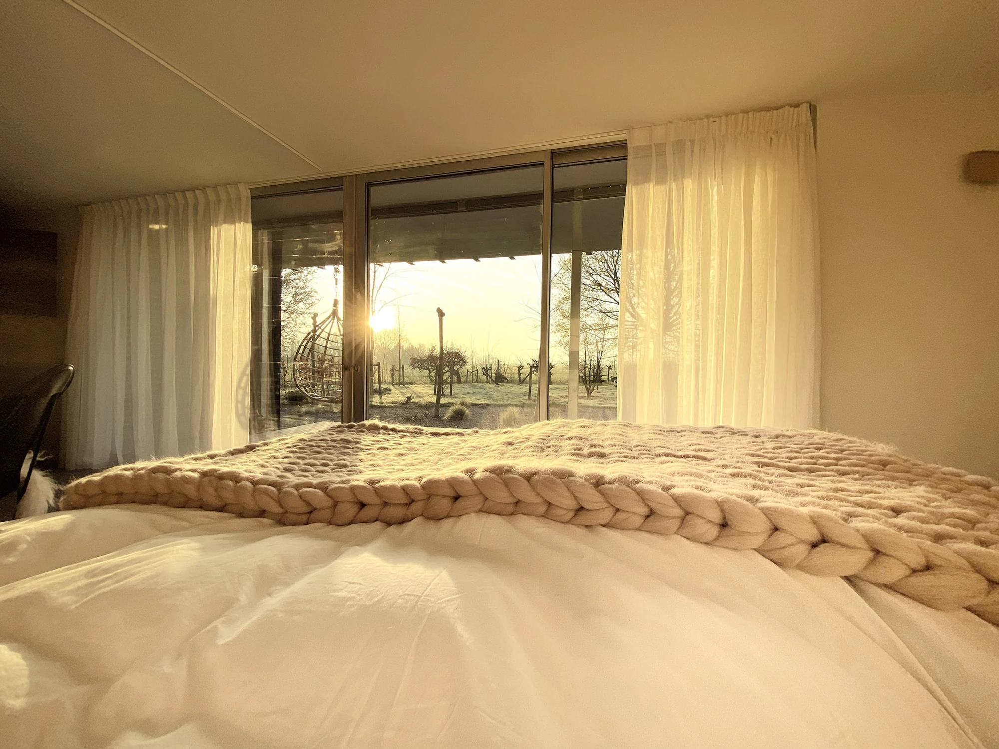 La chambre de la Suite Nordique face au lever de soleil givré, en hiver